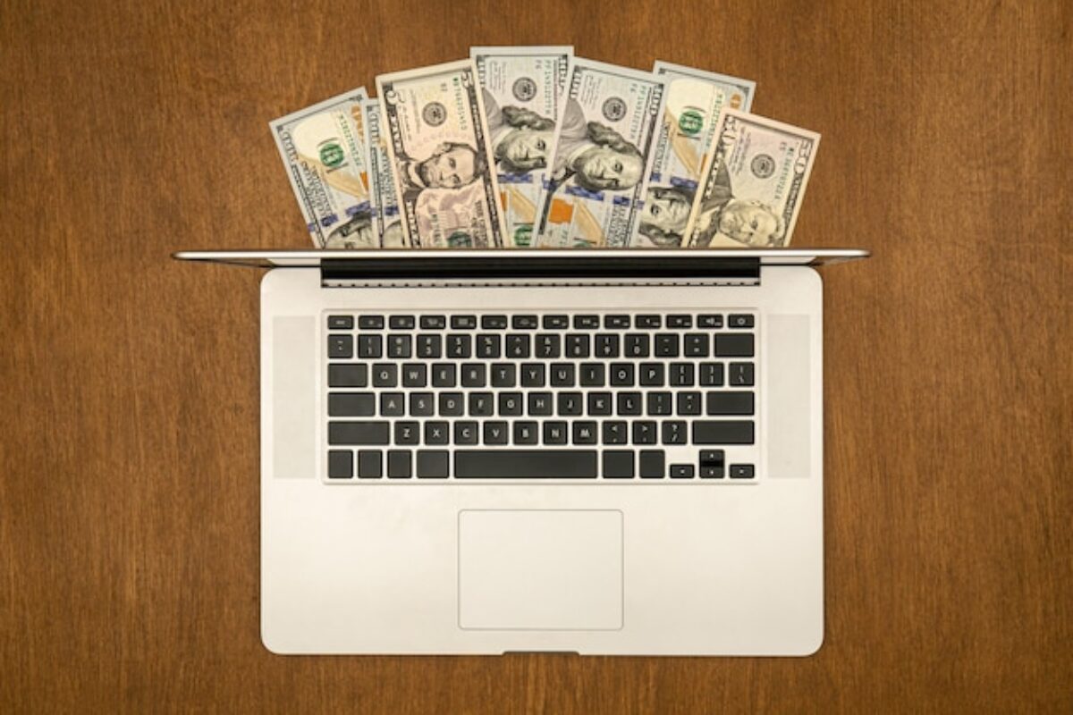 laptop-dollar-bills-wooden-background-flat-lay_169016-24683