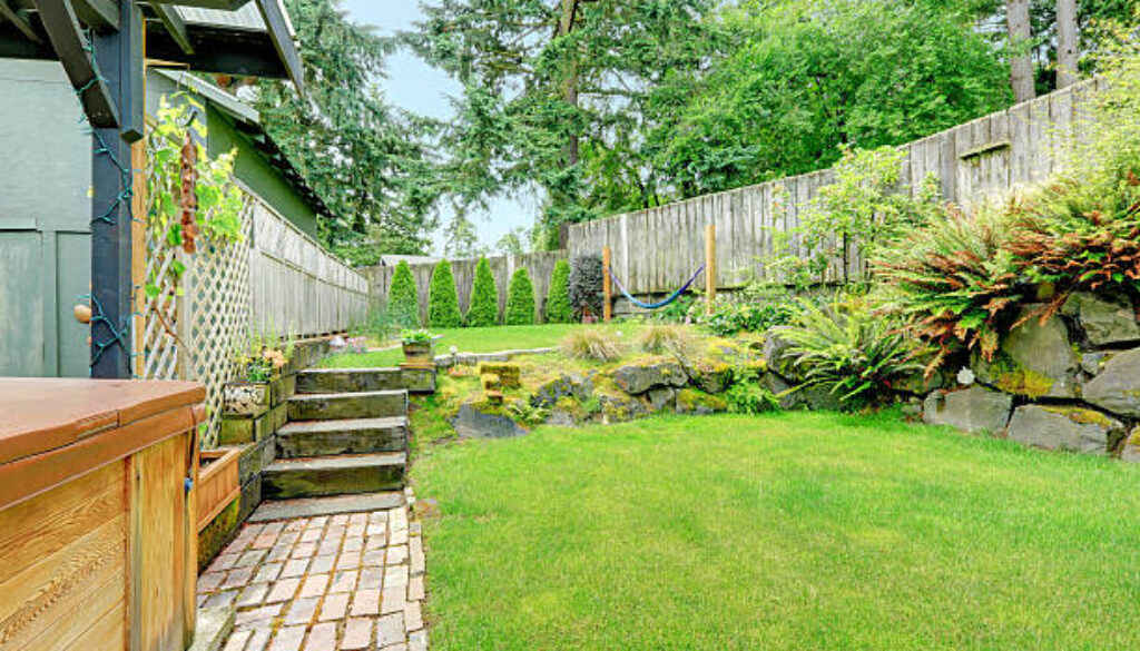 Backyard landscape design with stone trim. Brick tile floor walkway and stairs